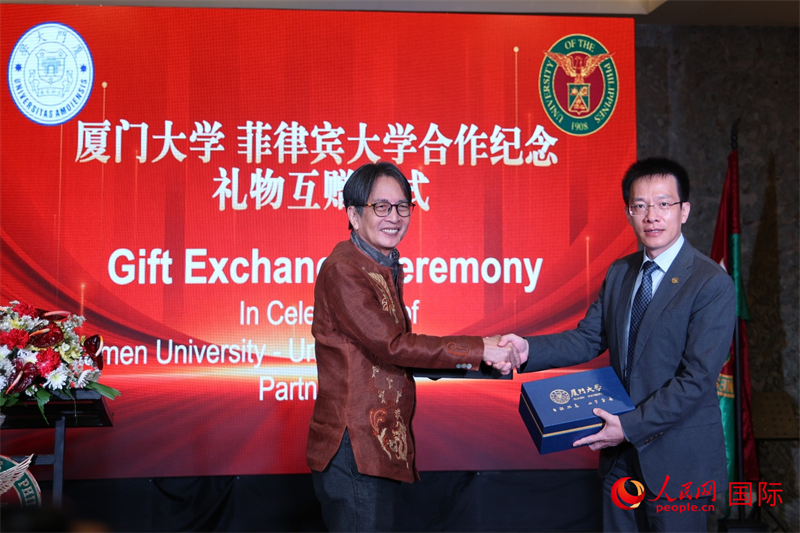 厦门大学副校长史大林与菲大迪利曼校区前校长陈万杰代表两校互赠纪念礼物，以志久谊。人民网记者 樊帆摄