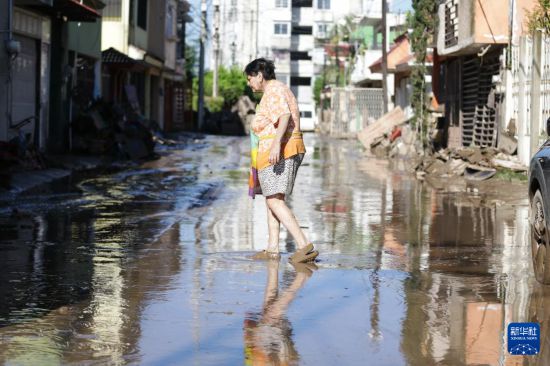 　　10月12日，在墨西哥韦拉克鲁斯州波萨里卡，一名妇女走过泥泞积水的街道。新华社发（弗朗西斯科·卡涅多摄）