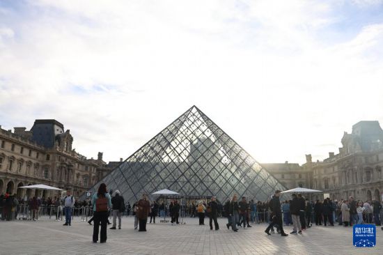 10月22日,在法国巴黎,大量游客聚集在卢浮宫博物馆的玻璃金字塔入口前。在法国卢浮宫抢劫案事发3天后,这座博物馆22日恢复开放。新华社记者 张百慧 摄