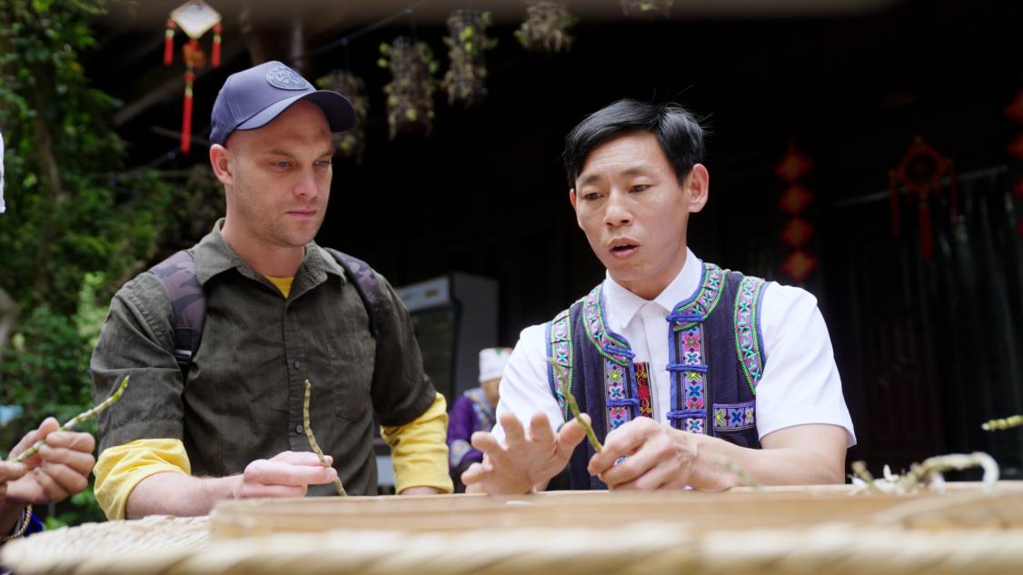 非物质文化遗产代表性传承人传承人张科长手持刚烘烤好的枫斗细细讲解