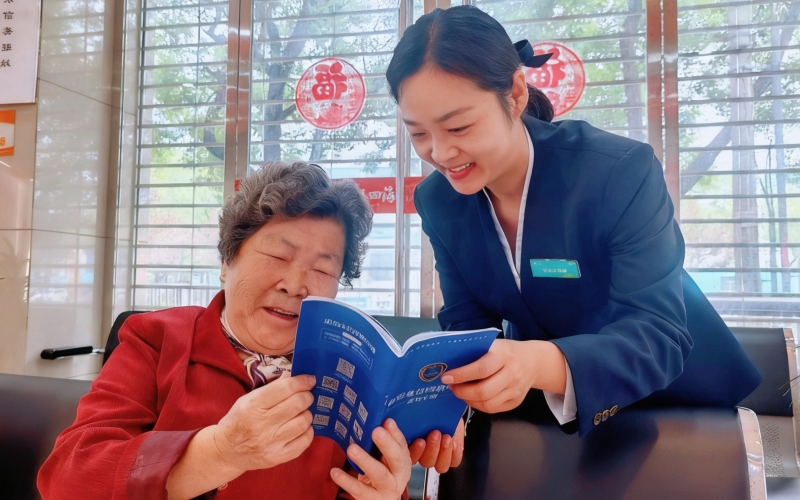 在中国移动营业厅内，工作人员细心地为老人讲解反诈知识。