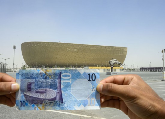 这是2025年4月17日在卡塔尔首都多哈以卢赛尔体育场为背景拍摄的卡塔尔10里亚尔纸币，纸币左边图案为卢赛尔体育场。